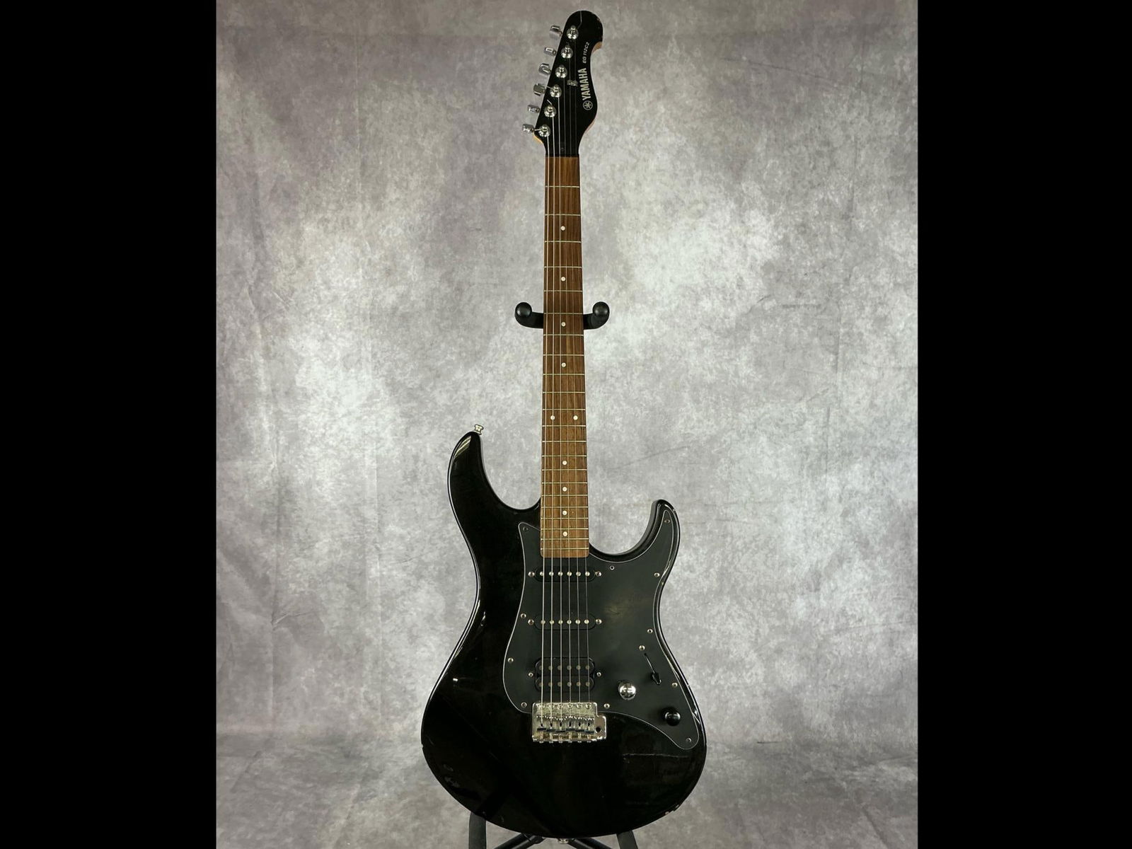 Yamaha EG-112C2 Electric Guitar: Yamaha eg-112c2 Stratocaster body from basswood in black metallic finish with black pick guard six string electric guitar. Two volume/tone knobs, five way selector switch, hss pickup configuration. Se