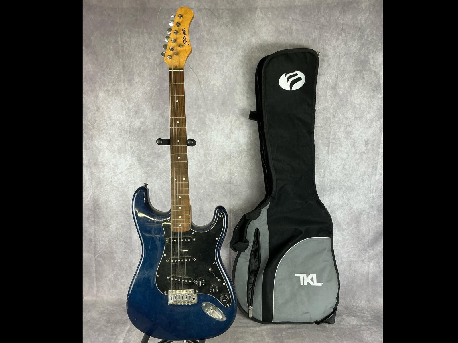 Stagg Stratocaster Electric Guitar: Stagg Stratocaster body from alder or poplar in blue finish with black pick guard six string electric guitar. Three volume/tone knobs, five way selector switch, bridge neck and middle pickups. Serial