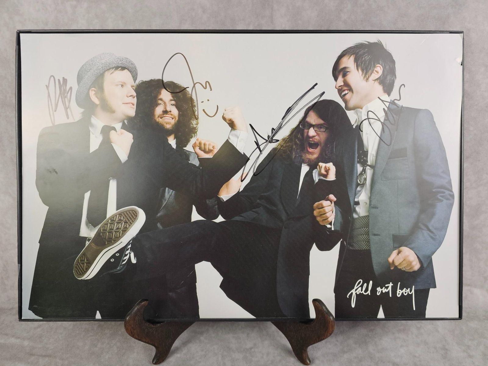 Autographed Fall Out Boy Poster: Autographed by all band members, poster of Fall Out Boy. No COA. Frame is missing glass, damage to top right corner of poster. Measures 17.25 inches wide x 11.25 inches tall.