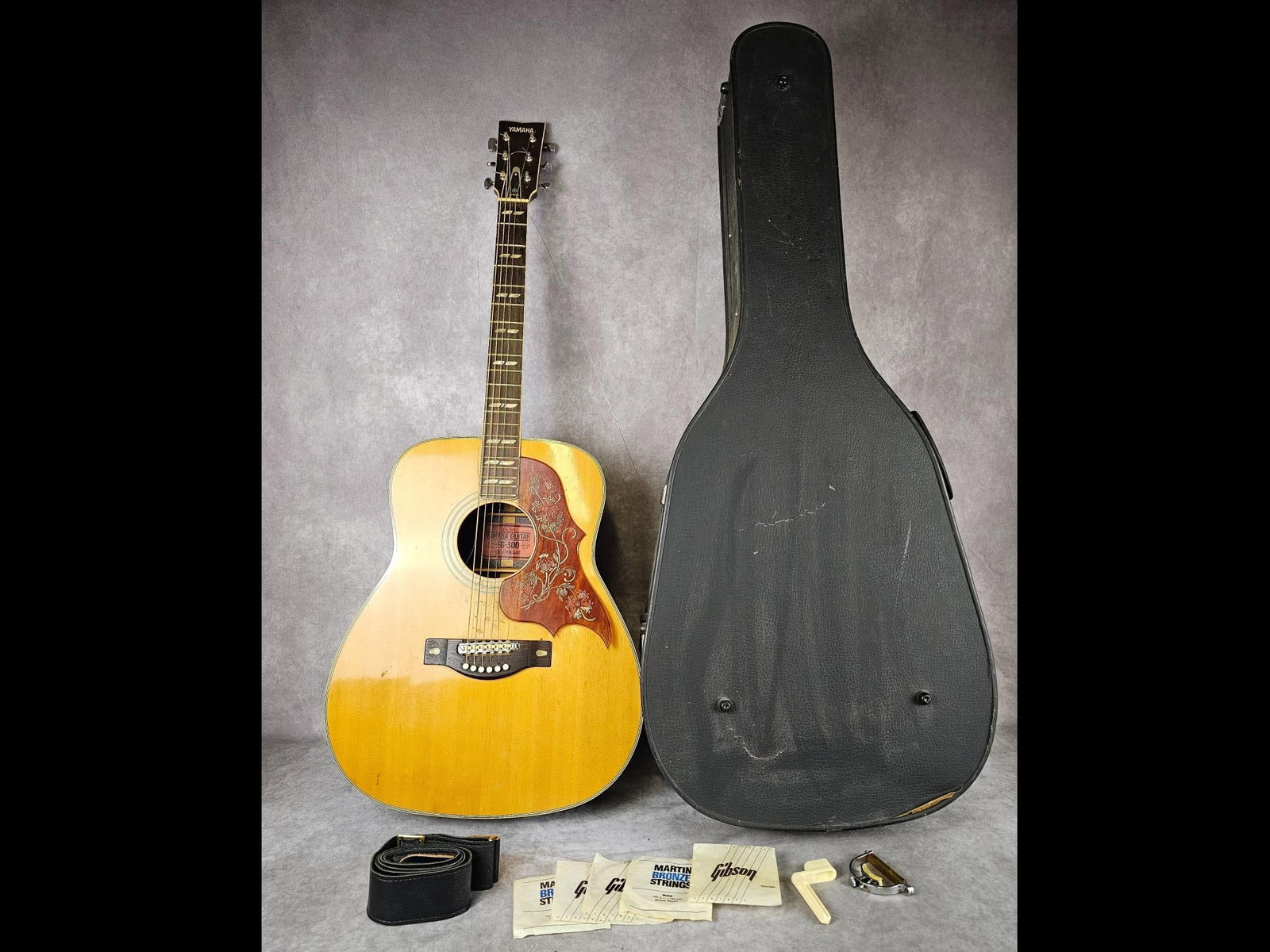 Yamaha FG-300 Guitar: 1971 Tamaha FG-300 Nippin Gakki red label, six string, acoustic guitar. Serial number 1028839. Etched faux tortoise shell pickguard, mother of pearl inlay, and an adjustable bridge. Pickguard is