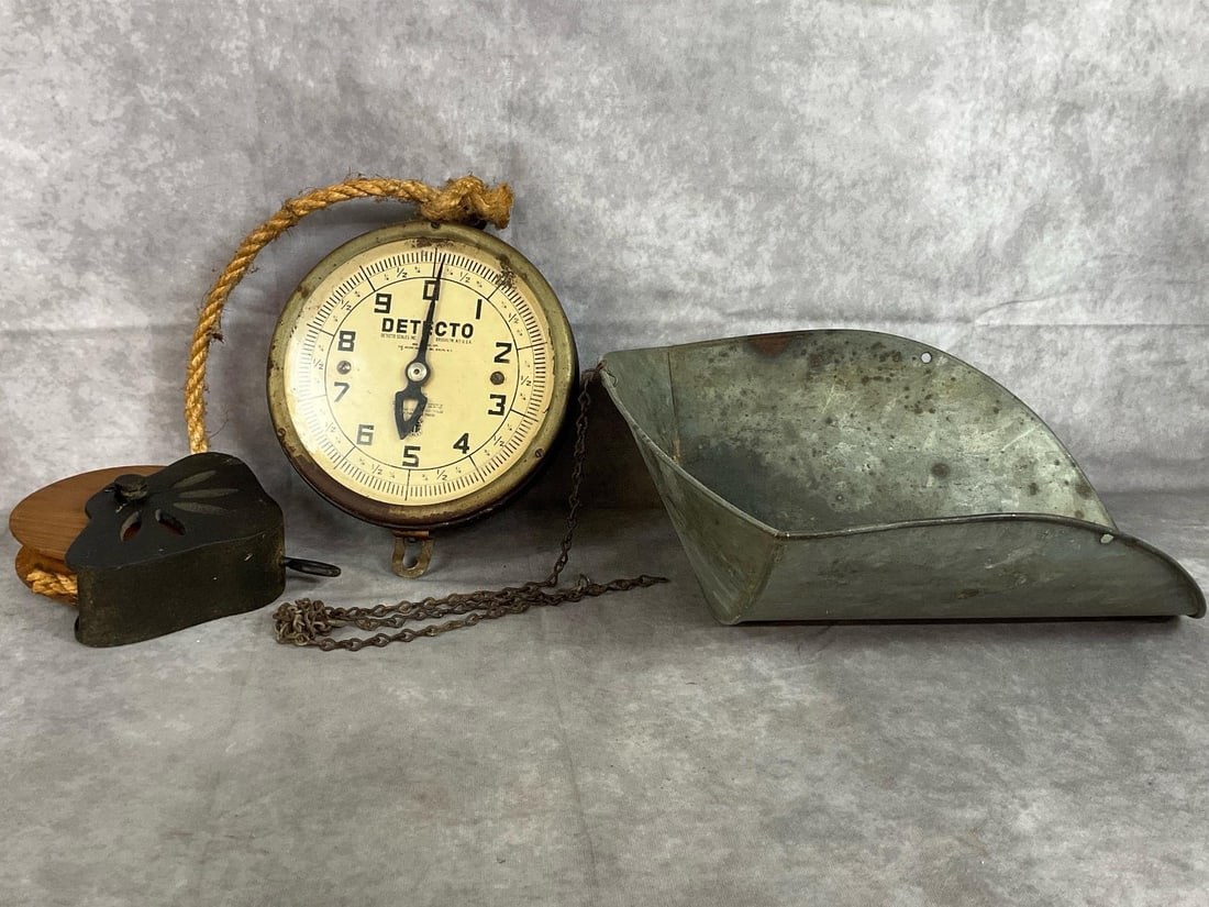 Detecto Hanging Scales: Early 1900s scale with late century pulley. Detecto round dial scale includes chain and galvanized metal scoop. Includes cast iron with wooden wheel pulley. Rust and wear present. Scoop measures 16