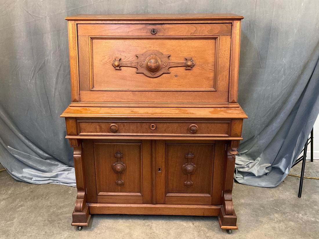 Eastlake Desk: Circa 1875 Victorian Eastlake walnut slant top desk with bird's eye maple and tulip poplar interior with burl walnut drawer on original castors. Interior desk mirror. Lower left cabinet door