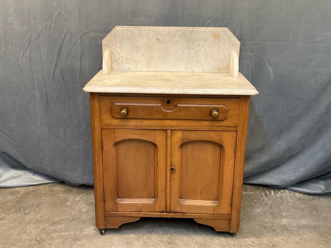 Victorian Washstand: Circa 1880 Victorian walnut and poplar one drawer over two door marble top washstand with marble back splash. Paneled construction. Illegible writing to backboards. Good condition. Measures 27.75