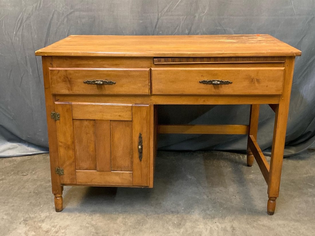 Writing Desk: Vintage mid - twentieth century maple two drawer over one paneled door writing desk. Some finish loss to top, otherwise good condition. Measures 42 inches wide x 23.25 x 30 inches tall.