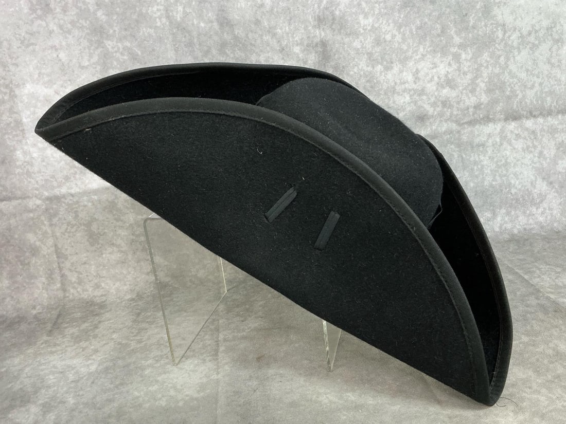 Tricorn Hat: Tricorn or “3 cornered hat” used in reenactment or pirate productions. Lined with logo “C H Co.” In good condition. Measures 14.5 inches on each side x 5.5 inches tall. Head size 7