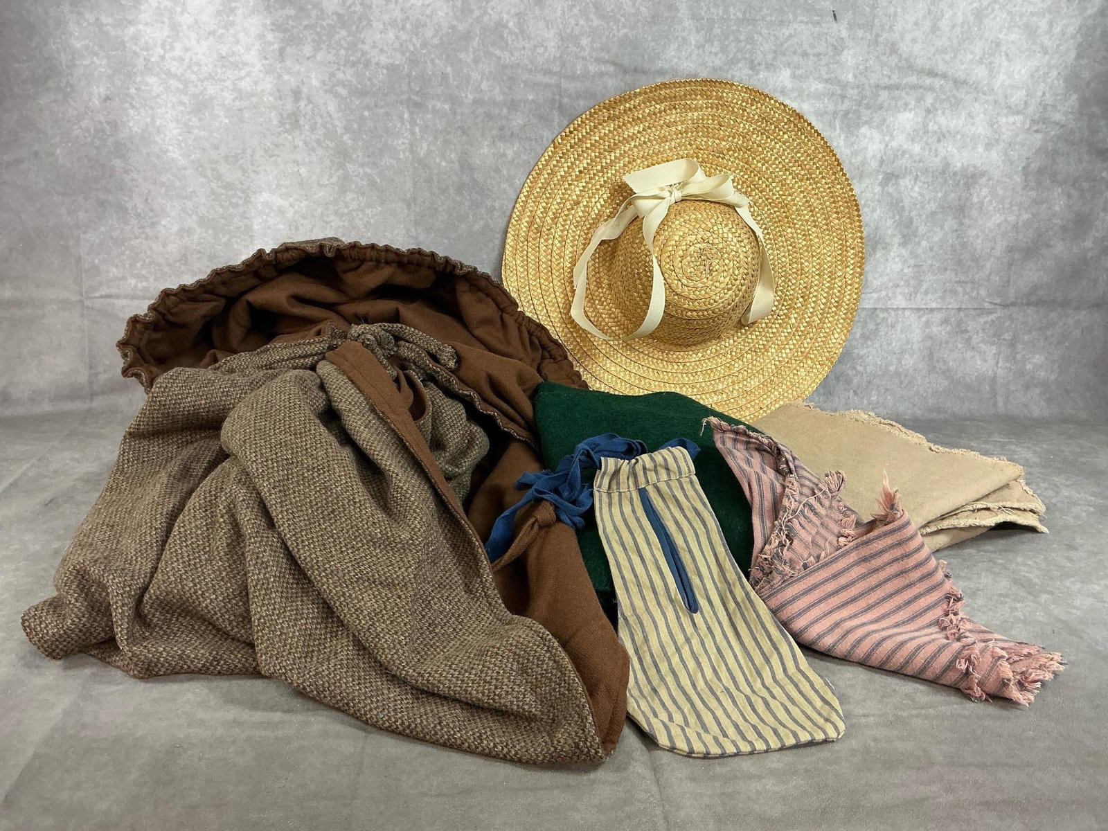 Reenactment Women's Cape, Hat, & More: Six pieces of reenactment women's clothing. Lined hooded brown cape, straw hat, wrist bag, two pieces of fabric, and scarf. Cape measures 51 inches from neck to hem x 62 inches wide. Hood measures