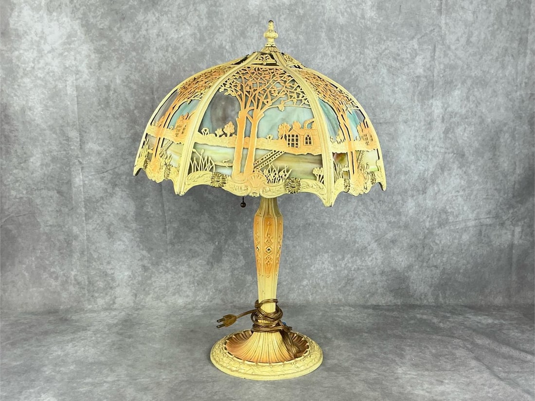 Arts & Crafts Slag Glass Lamp: Early 20th century Arts and Crafts six paneled slag glass lamp with trees, house, and lake scene. Attributed to Miller Lamp Co.. Repainted, base cover loose, and upper lead shade bent and damaged.