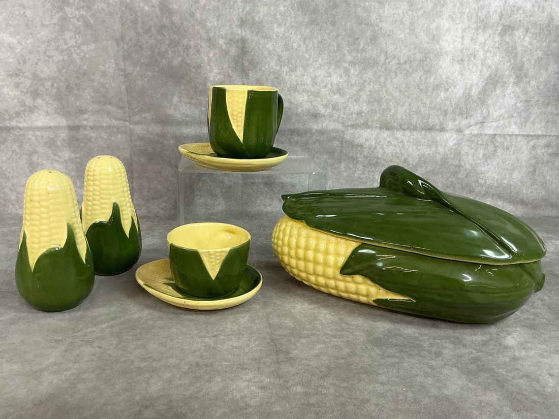Shawnee Corn King Pottery: Seven mid-century pottery pieces. Shawnee USA Corn King casserole with lid, two shakers, two saucers, coffee cup and mug. All in good condition. Casserole measures 11 inches long x 5 x 5.5 inches