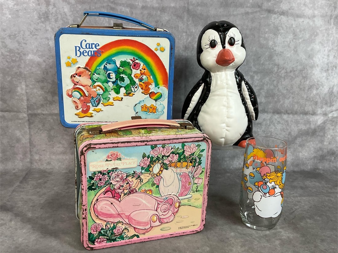 Collectible Lunchboxes, Ceramic Penguin, & Popple Glass: Four mid eighties collectibles. Care Bears and Rose Petal Place metal Aladdin lunchboxes, Kimple ceramic penguin, and Puffball Popple 16 oz glass tumbler. Lunchboxes have rust and a few dents.