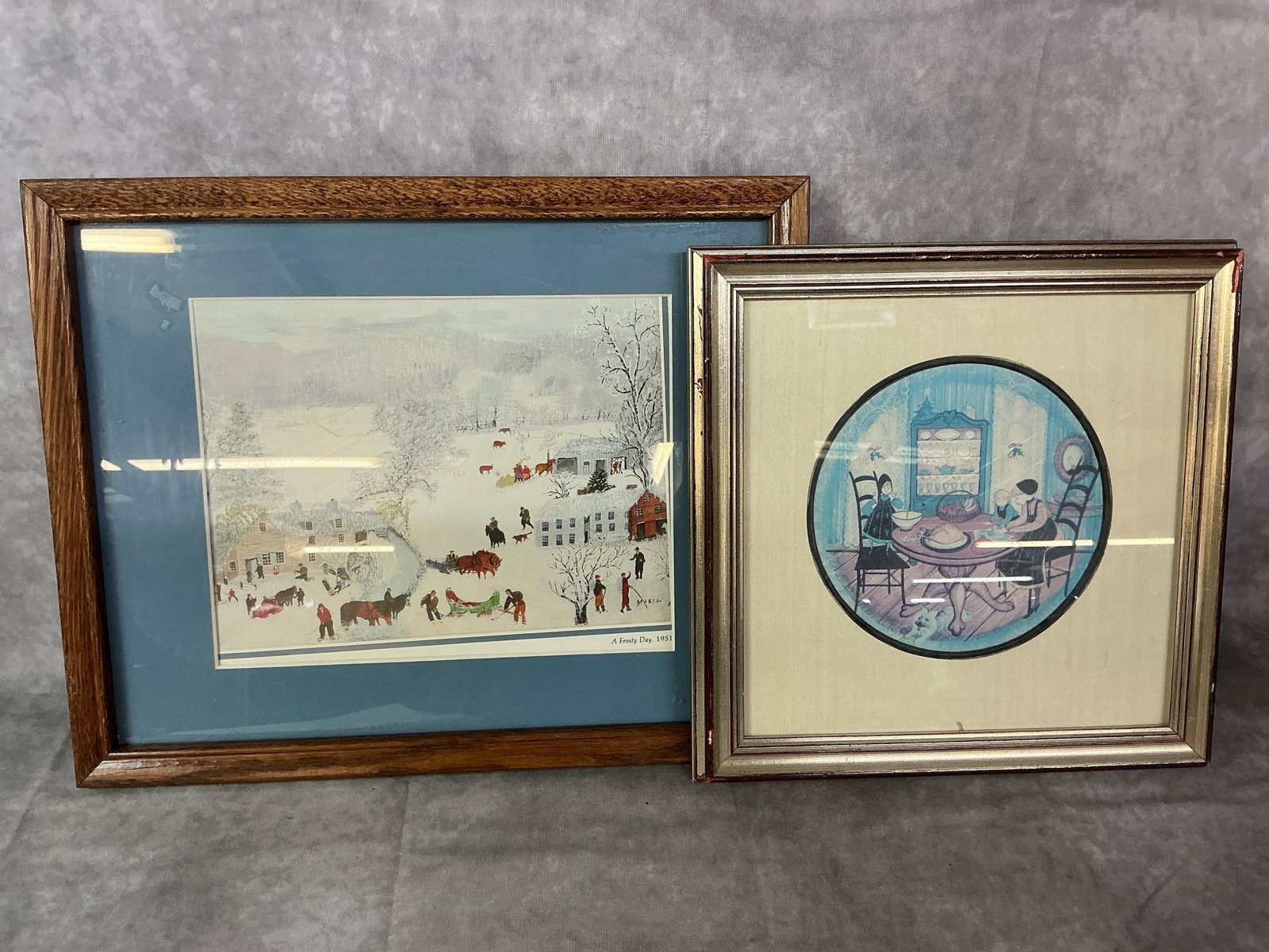 P Buckley Moss & Moses Art: Two mid century framed and matted prints. P Buckley Moss "Helping Hands" print, and "A Frosty Day" folk art by Anna Mary Robertson Moses. Hands print is faded and Frosty Day has slipped in matting.