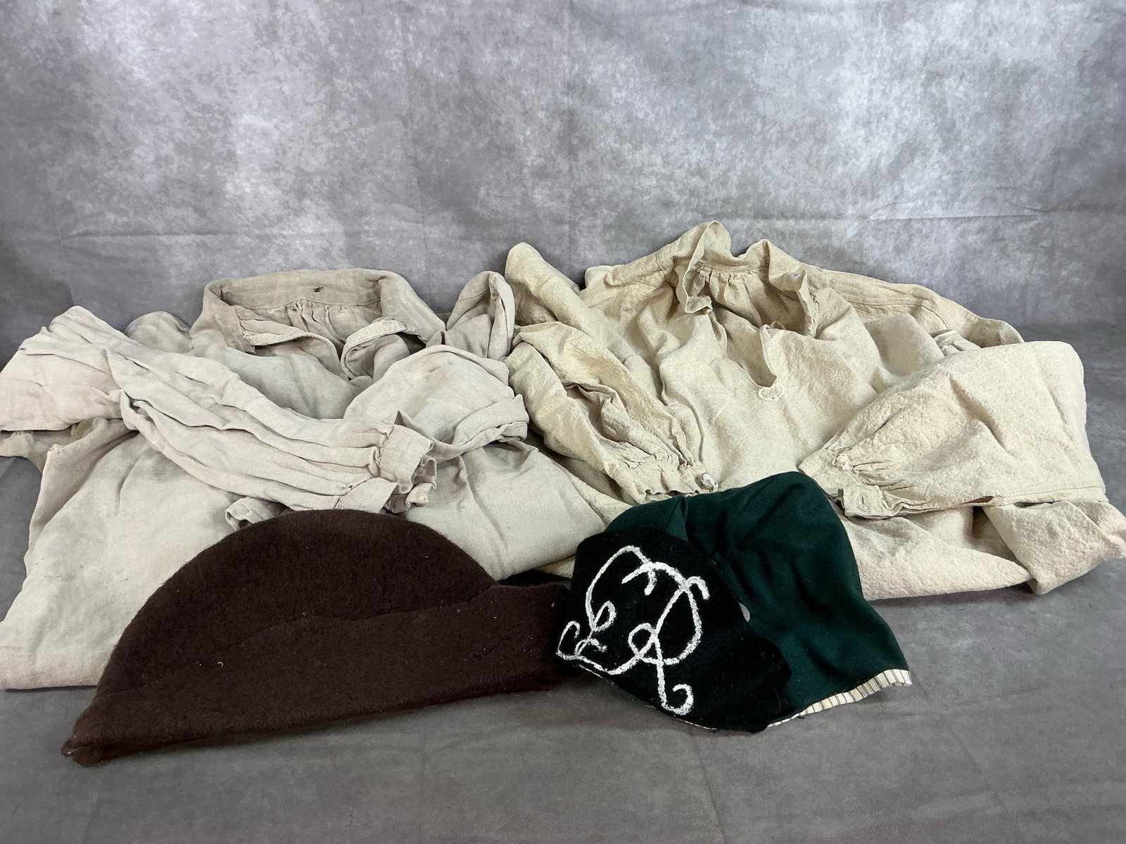 Reenactor's Shirts & Forage Caps: Two shirts and 2 caps made in late 1900's (reproduction styles from 1700's). Shirts are long heavy broadcloth and stained from wear. Bonnets, or forage caps are homemade. Largest shirt measures 43 inc