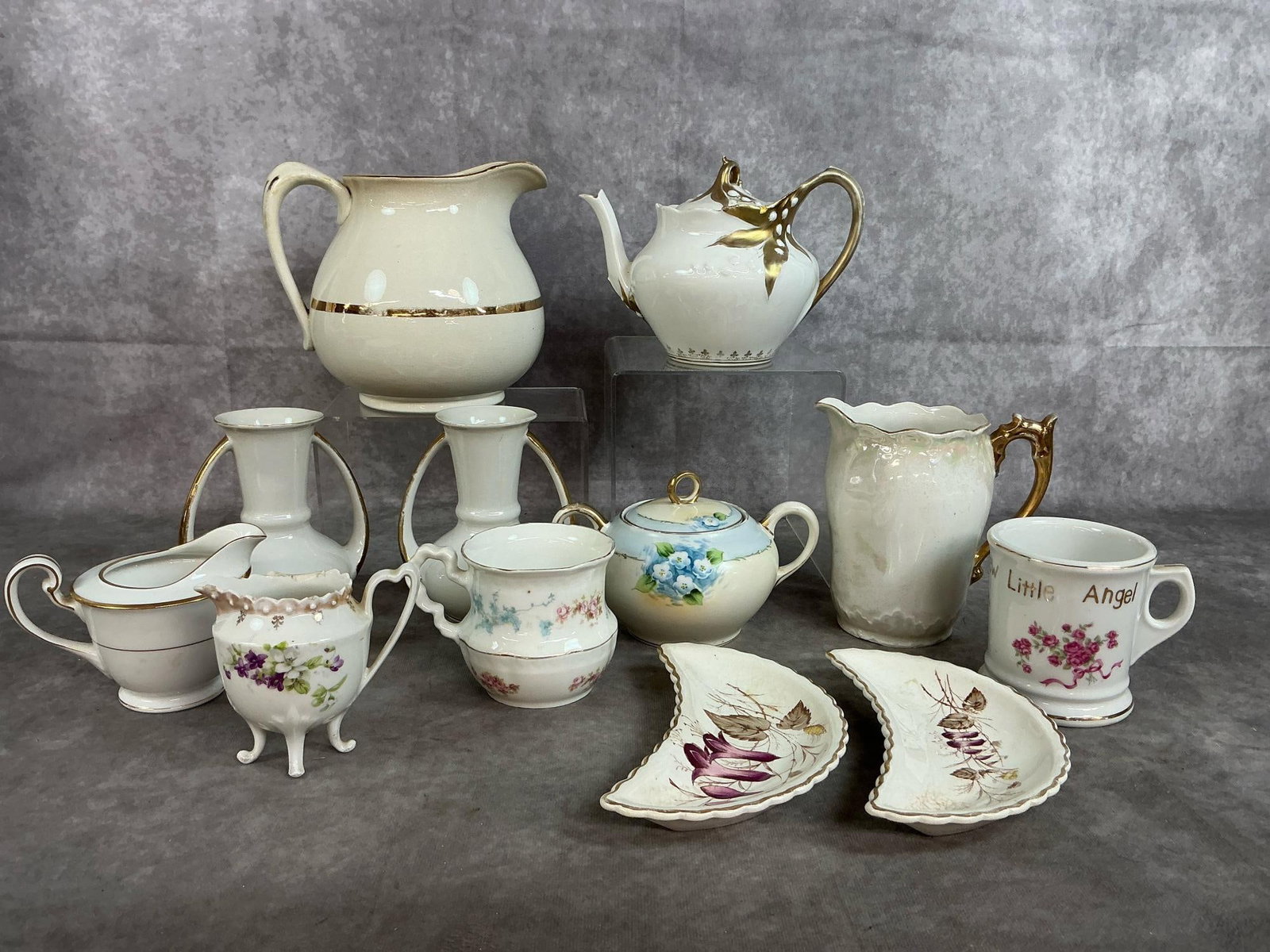 Collectible Vases, Pitchers, and Dishes: Twelve early to mid century serving pieces. Large Wellsville pitcher with gold trim, two vases with gold trim, creamer, teapot and small pitcher with gold trim. Includes Little Angel cup, blue floral
