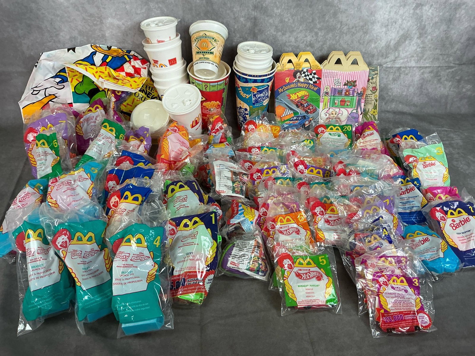 McDonald's Happy Meal Toys: Seventy-four toys from 1997 to 2000. Includes Barbie, Hot Wheels, Goofy Movie, and Little People. Includes meal boxes, cups, and bags. Toys in original packaging.