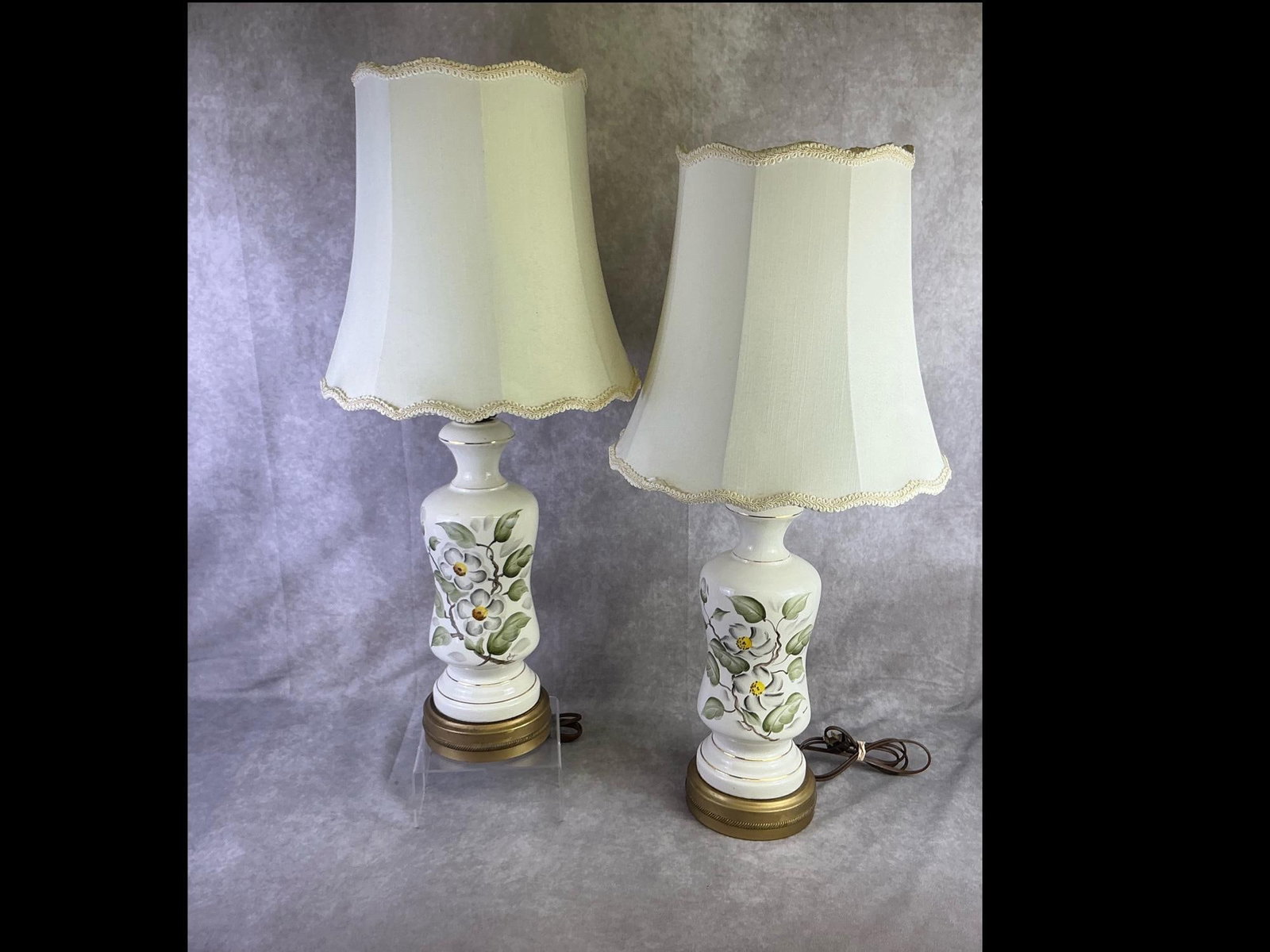 Ceramic Table Lamps: Pair of 1950s to 1960s ceramic table lamps featuring a hand painted floral design. Both in good working condition with crazing present throughout. Each measures 6.25 inches wide at base x 30 inches