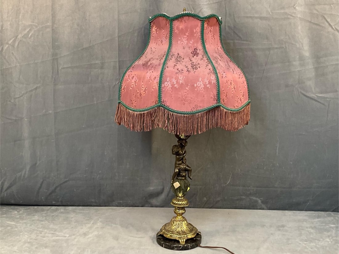 Cherub Lamp: Mid - twentieth century vintage brass and marble base cherub lamp with silk tasseled shade. Loose socket. Good condition, lamp works. Measures with shade 18 inches wide x 35 inches tall.