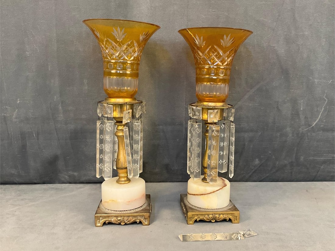 Mantel Lustres: Pair of early twentieth century brass and marble mantel lustres with prisms and Bohemian cut amber glass hurricane shades. Previously electrified with one broken prism, and cracked shade. Measures 5