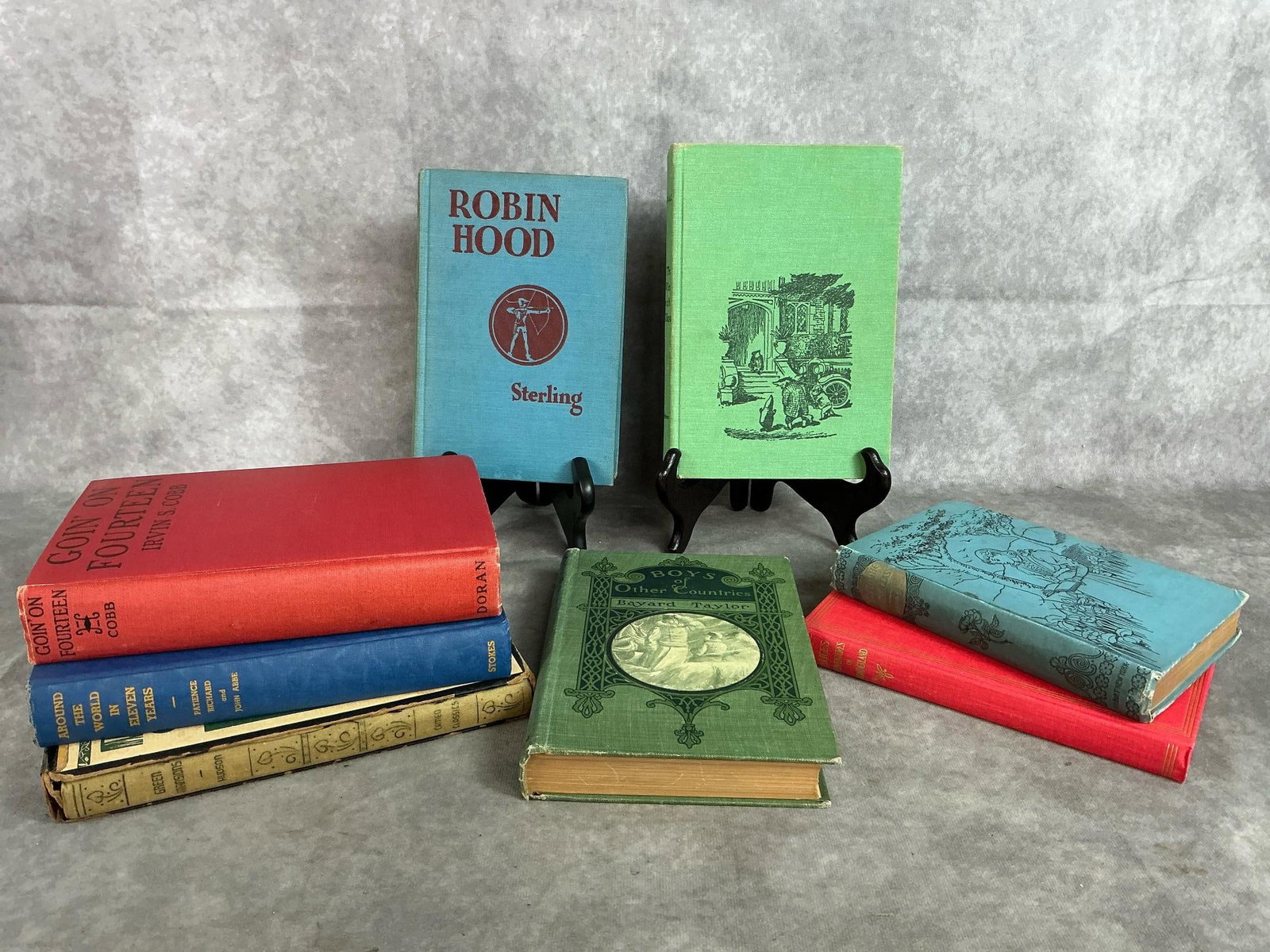 Classic Books: Eight hardback books from late 1800's to mid 1900's. Includes Robin Hood (1921), Through the Looking Glass (1890's), Wind in the Willows (1961), and more. Some foxing, otherwise books are in good