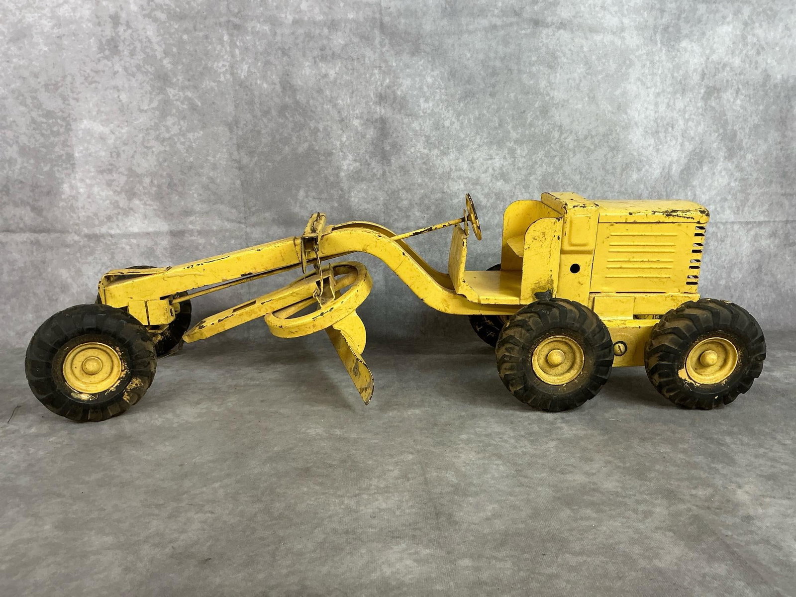 Vintage Toy Grader: Mid 1900's pressed steel Adams Motor road grader. Made by Doepke Model Toys. Scratches and paint loss present. Measures 25 inches long x 8 x 7.5 inches tall.