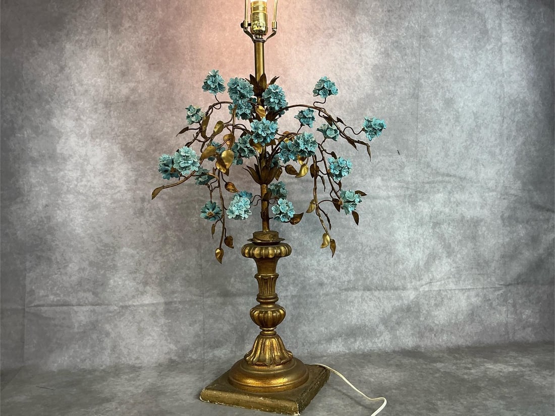 Hydrangea Table Lamp: Mid 1900's Italian tole and porcelain table lamp. Blue hydrangeas with gold gilt leaves on pedestal stand. No shade. In good condition. Measures 8 inches square at base x 39 inches tall.