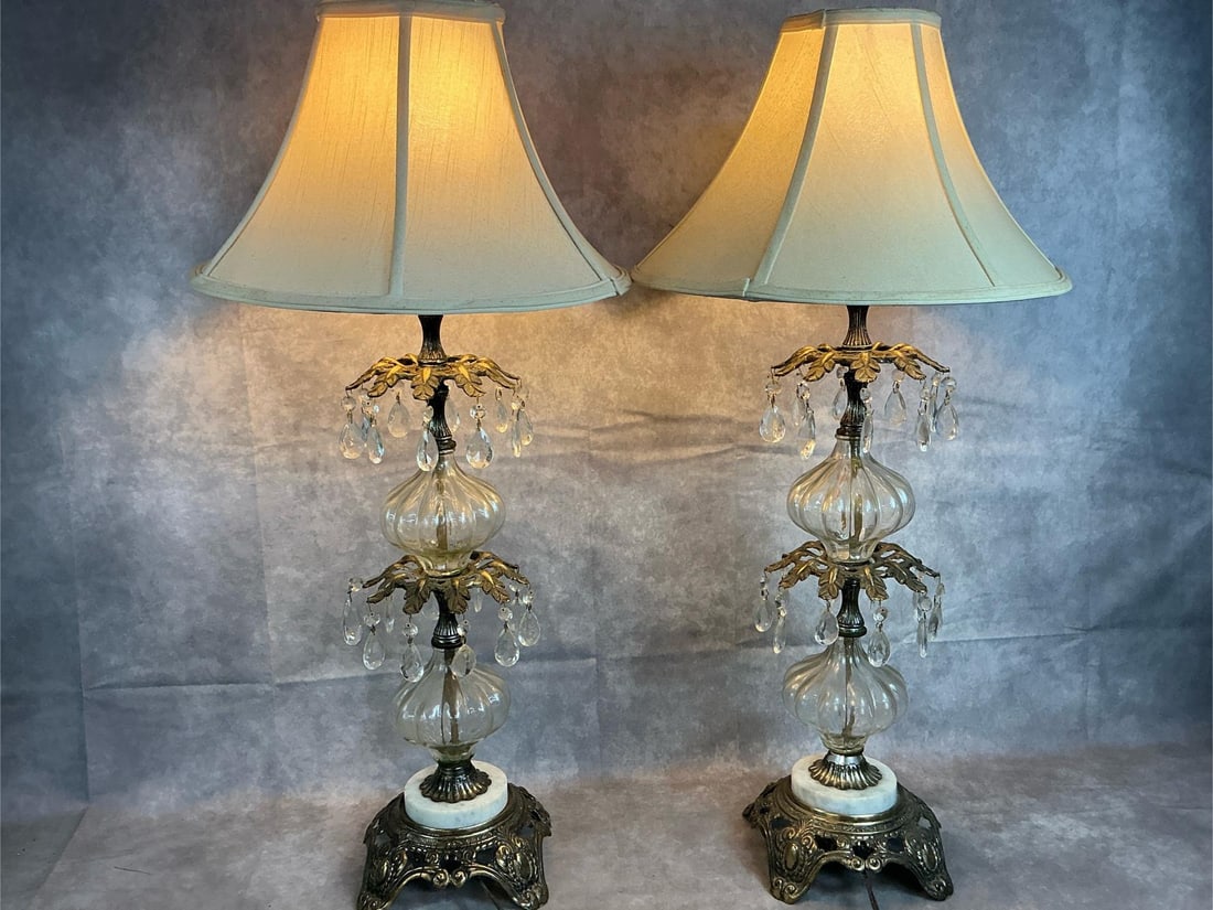 Hollywood Regency Crystal & Brass Lamps: Two 1970's table lamps. Ornate Hollywood Regency style with crystal prisms, marble base, and brass stand. Both work. Lampshades are dusty, otherwise in good condition. Lamp base measures 7 inches wide