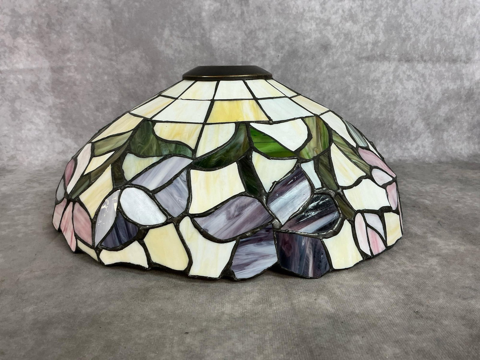 Art Stained Glass Shade: Stained glass lamp shade with daffodil pattern. Geometric upper section with floral border. Copper center ring. In good condition. Measures 13 inches in diameter x 5.5 inches tall.