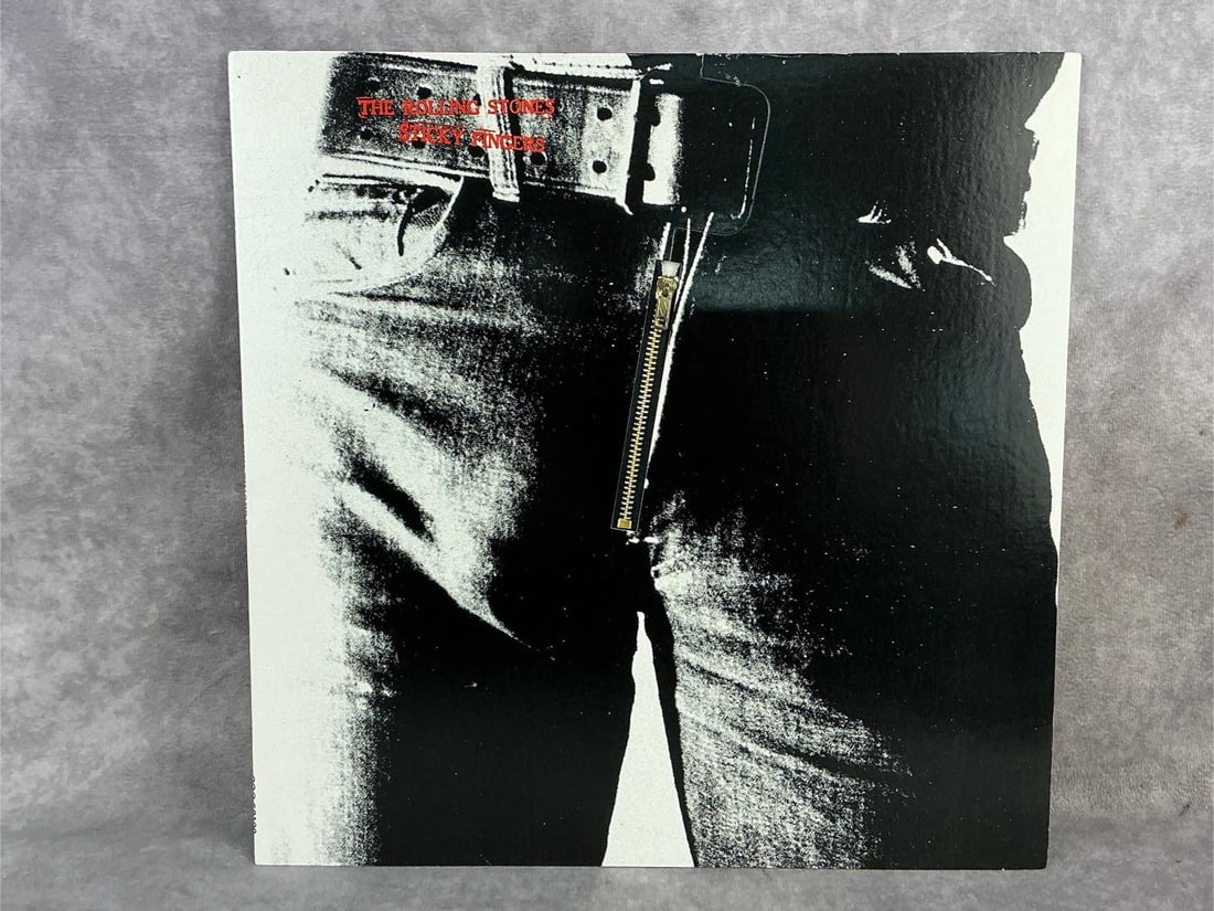 The Rolling Stones Vinyl: 1971 The Rolling Stones vinyl titled Sticky Fingers. In good condition with original sleeve. Measures 12.5 inches wide x 12.25 inches tall.