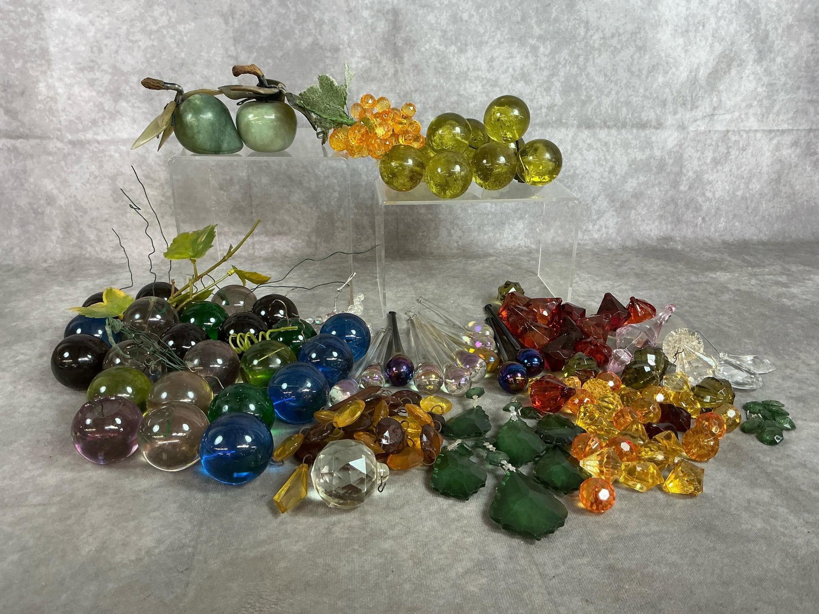 Jade Fruit, Glass Marbles, and Crystal Decorations: Lot of mid century decorative fruit and pieces. Includes jade apple and pear with stone etched leaves. Eleven long iridescent teardrop glass, lucite acrylic grapes, in cluster and loose. Variety of