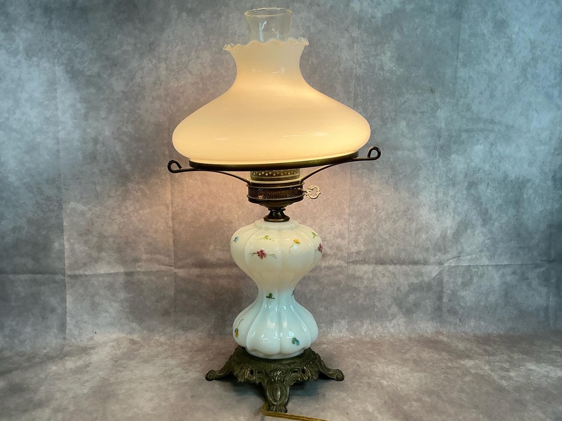 Milk Glass Table Lamp: Vintage milk glass Gone with the Wind table lamp. Handpainted delicate floral design, ruffled top shade, and ornate metal base. Bulb base is slightly loose, otherwise in good working condition.