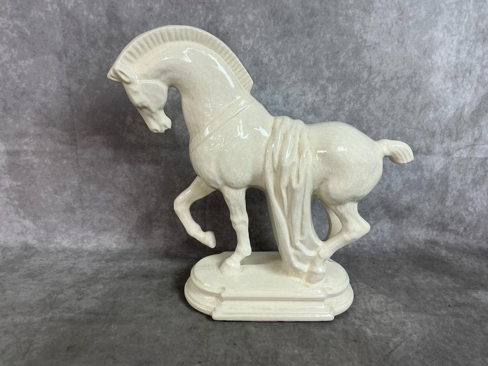 Prancing Trojan Horse Statue: Mid century modern ceramic horse. White glazed prancing horse shows crazing. Measures 12 inches long x 4 x 12 inches tall.