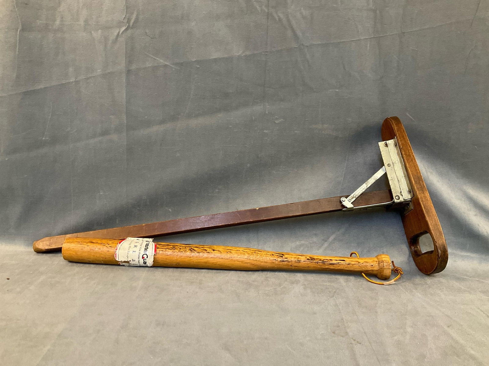 : Mid - twentieth century lot of two vintage collectibles. One "Sit Stick" and one "Fire Bat" for breaking windows in the event of a fire. Good condition. Bat measures 21.75 inches wide x 1.5 x 1.5