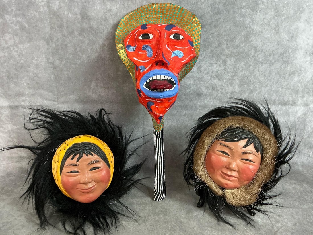 Folk Art Rattle & Eskimo Face Art: Three late 1900's pieces. "Rattlemouth" art mask with handle and beans inside. Two faux fur Eskimo face wall hangings. Slight paint loss on faces, otherwise in good condition. Rattle measures 6