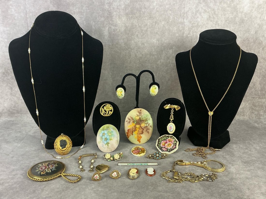 Costume Jewelry: Twenty pieces of vintage costume jewelry. Includes three hand painted on porcelain brooches, cameos, floral clip on earrings, brooches, necklaces, a handheld mirror and magnifying glass. Cameo