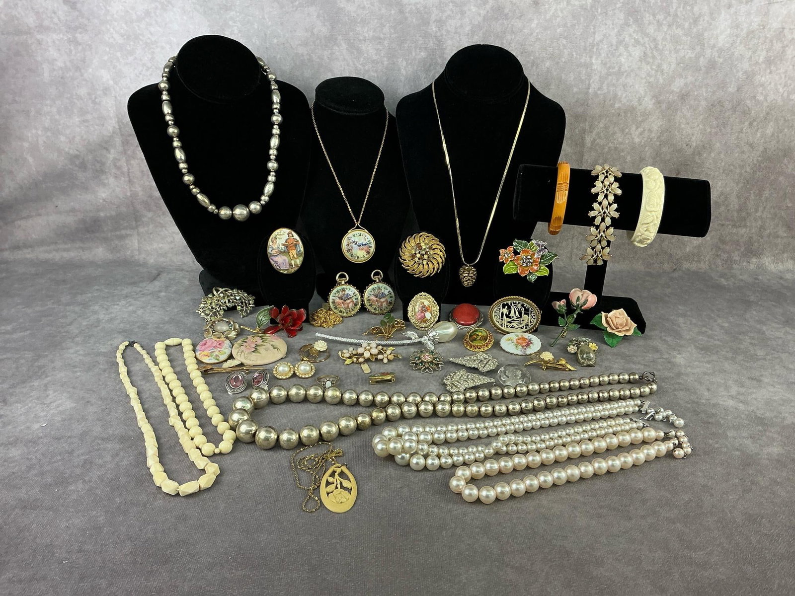 Costume Jewelry: Over forty pieces of costume jewelry including necklaces, brooches, earrings, and a ring. Hand painted porcelain brooch, carved bone necklaces and a brooch, one micro mosaic brooch, and more. One