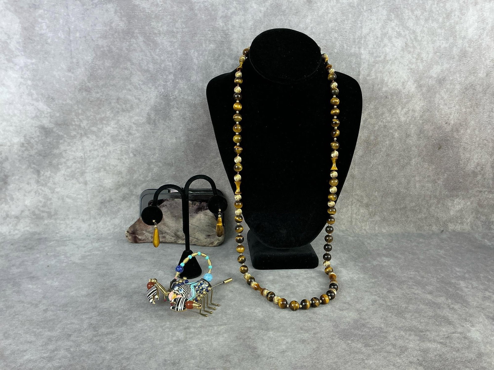 Cynthia Chuang Brooch & More: Vintage scorpion brooch made by Cynthia Chuang, porcelain body with brass springs and legs, marked Jewelry 10 on the bottom. Tiger's eye necklace with gold tone bead accents and matching earrings.