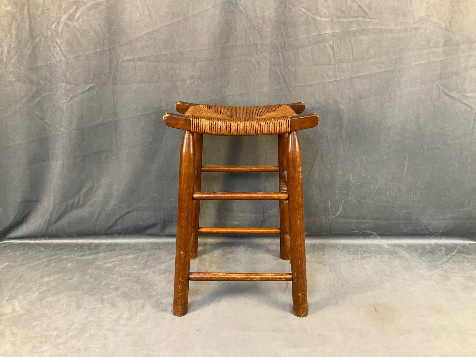 Vintage Country Stool: Mid-20th century vintage country stool with rush seat. Scratches and wear to finish, otherwise good condition. Measures 15 inches wide x 10 x 21.75 inches tall.