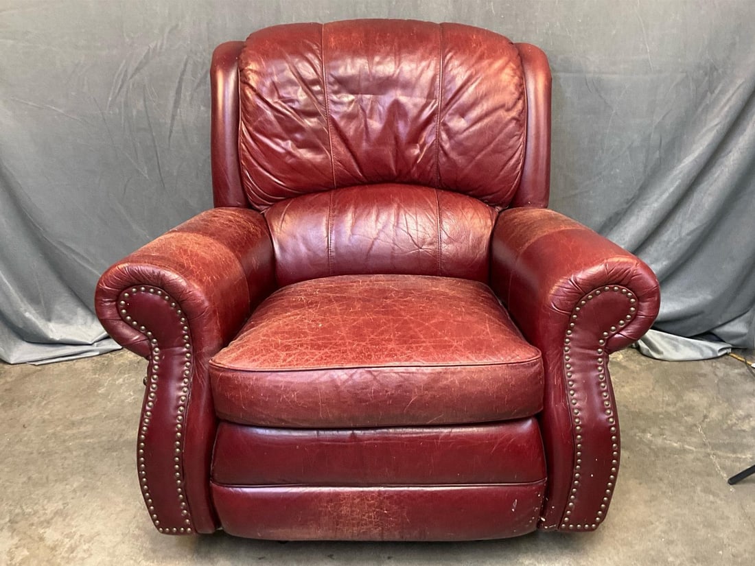 Reclining Chair: Late 20th century red leather adjustable recliner with brass tack decoration. Scuffs to leather, otherwise good condition. Measures 43 inches wide x 39 x 38.5 inches tall.