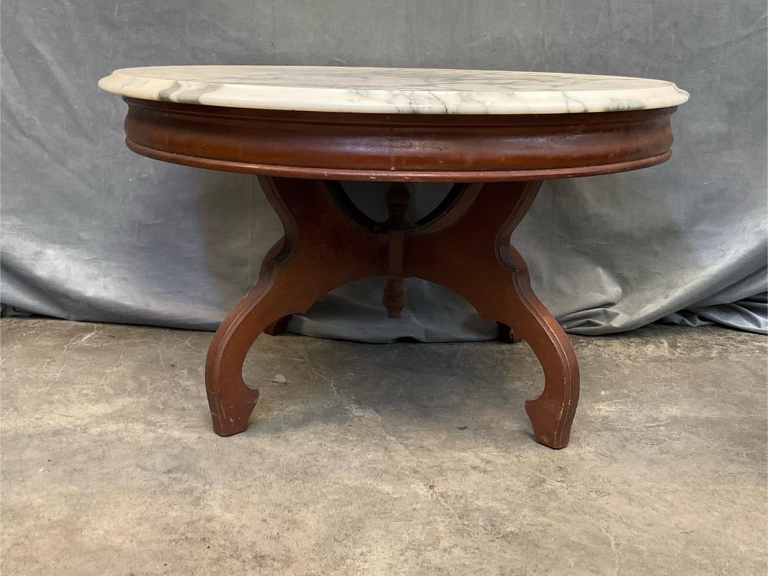 Eastlake Coffee Table: Mid-20th century Eastlake Style marble top mahogany circular table. Marked "Victorian". Some water stains to table, otherwise good condition. Measures 30 inches in diameter x 17 inches tall.