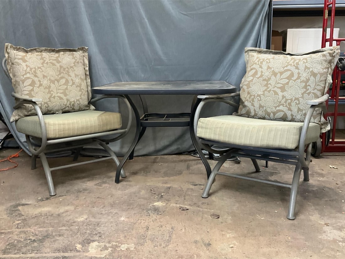 Outdoor Table/Chairs: Early 2000's Outdoor Set of iron/glass table with two chairs and cushions. Good condition. Cushions in used condition. Table measures 39.75 inches wide x 39.75 x 28 inches tall.