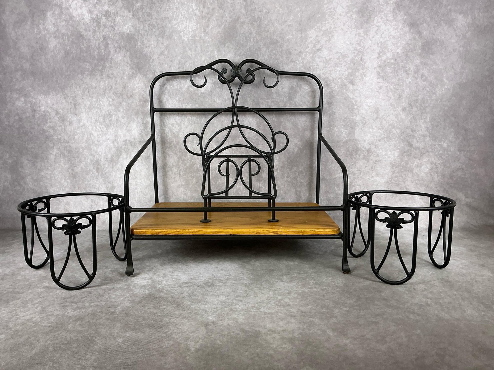 Longaberger Stands: Four wrought iron pieces including a newspaper stand with wooden insert bottom, letter holder, and two plant stands. Some rust on one foot of newspaper stand, otherwise all in good condition. Largest