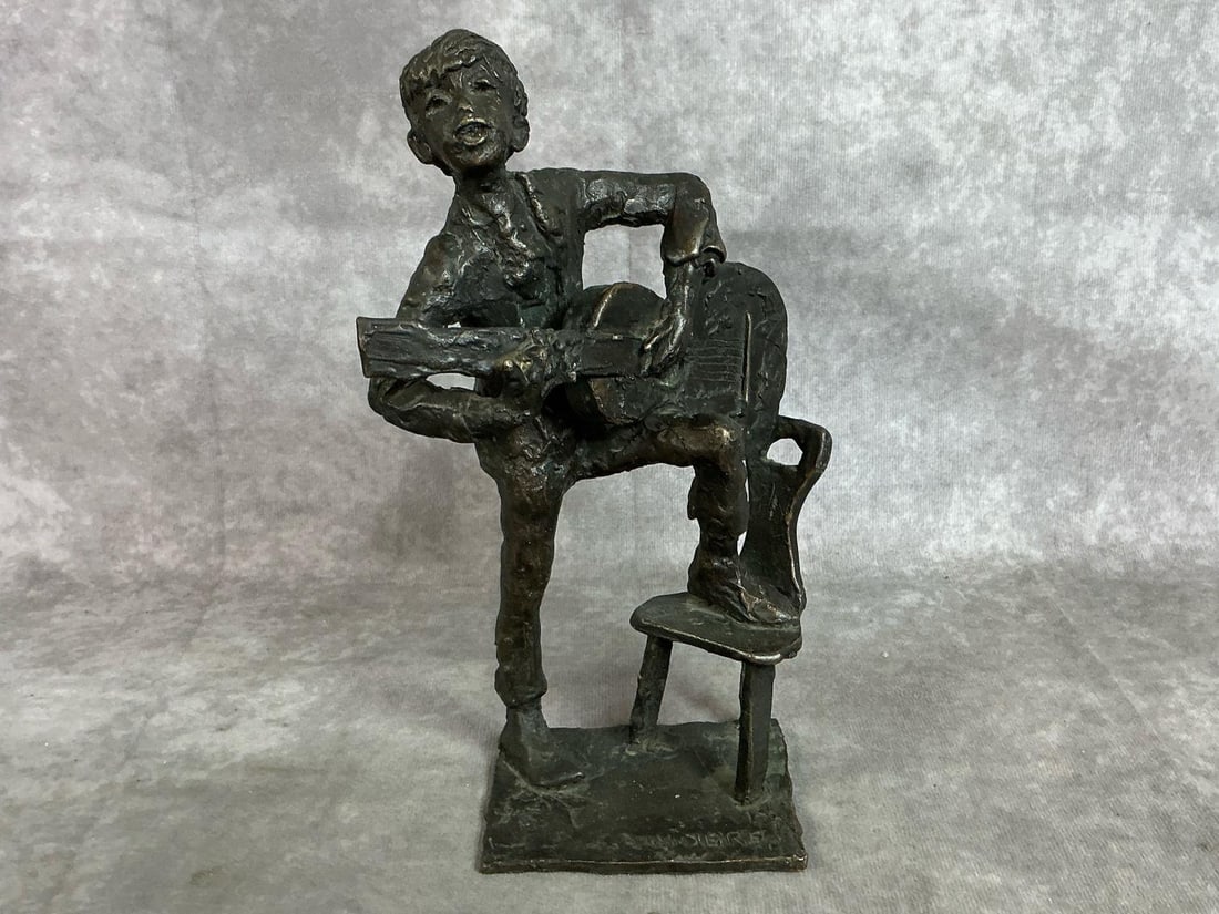 Boy & Guitar Sculpture by J C Sanders: Modern bronze sculpture by Jill Cowie Sanders, British artist. Boy with guitar signed by artist on base. Measures 6.25 inches wide x 3 x 9.5 inches tall.