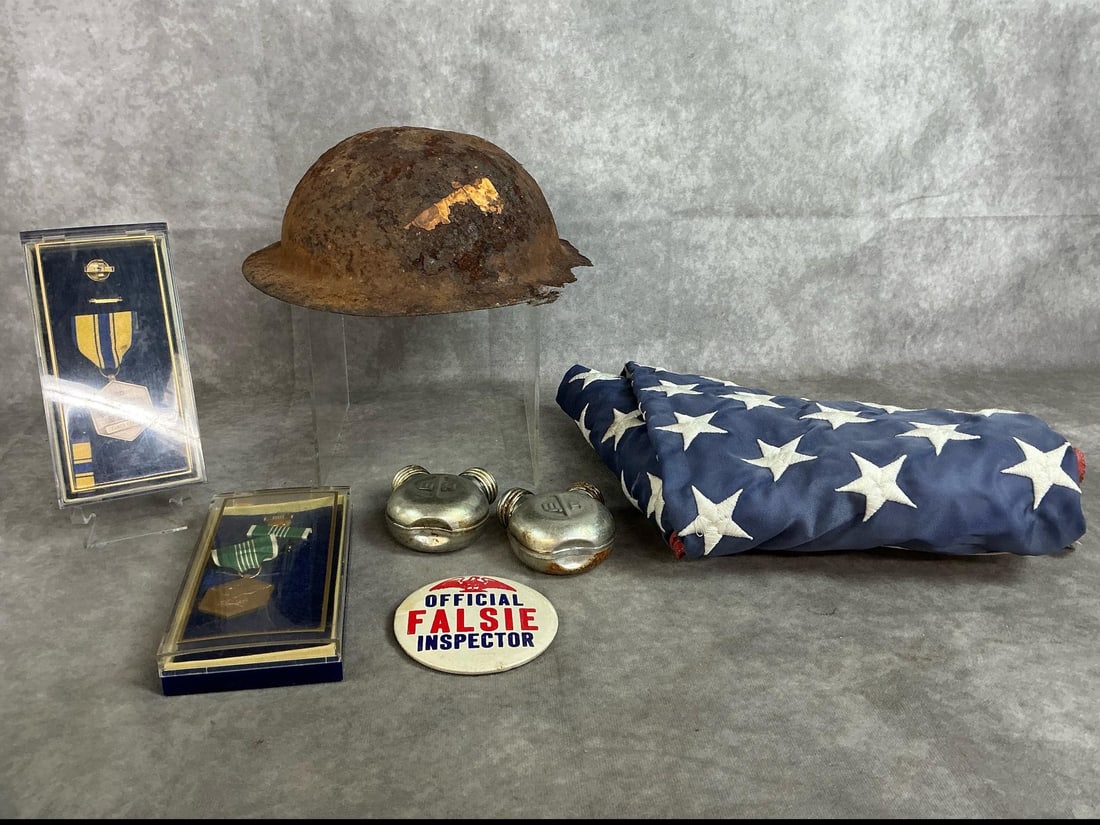 Military Badges, Helmet, Flag & More: Seven early to mid 1900's military items. Two military merit badges in clear boxes, two gun oiler metal bottles, and WWI helmet. Includes American flag and humorous badge. Rust and wear present. Flag