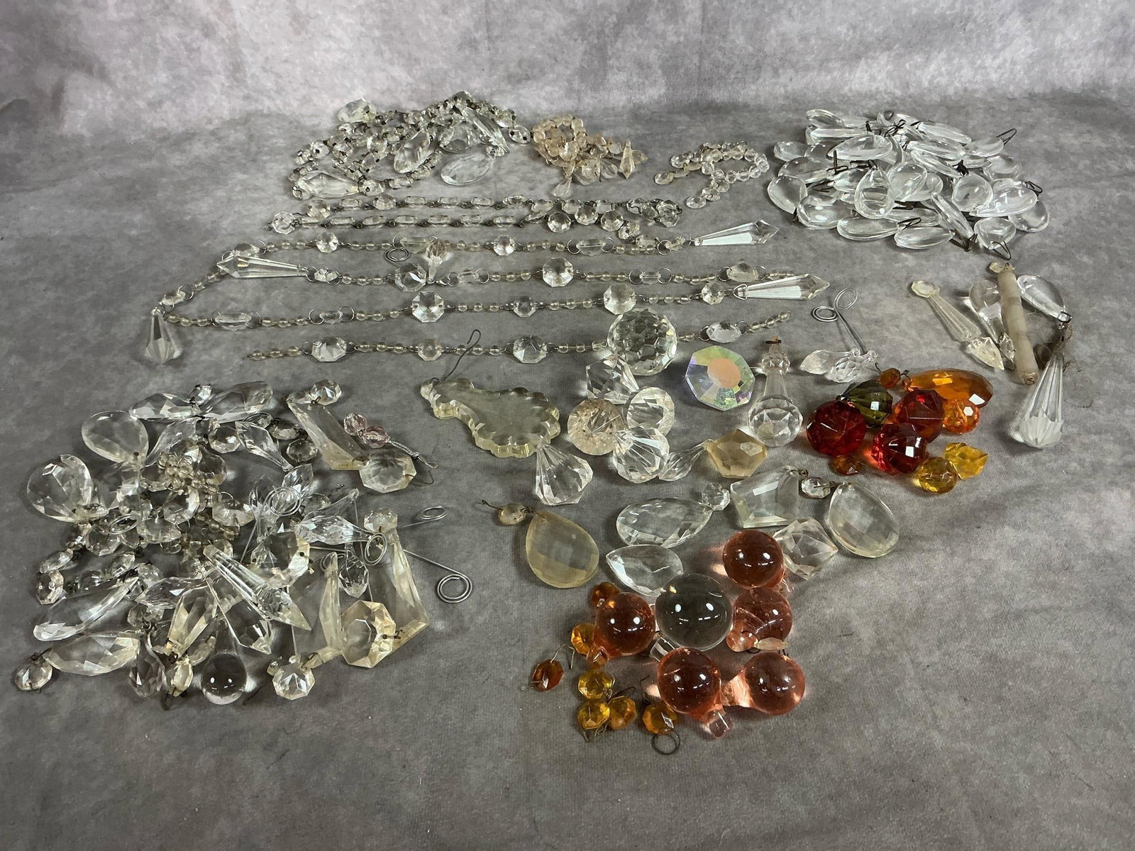 Crystal Prisms Assortment: Over 100 crystal faceted prisms from mid 1900's. Replacement prisms for chandeliers and lamps. Varied shapes and colors. Strands measure as long as 16 inches.
