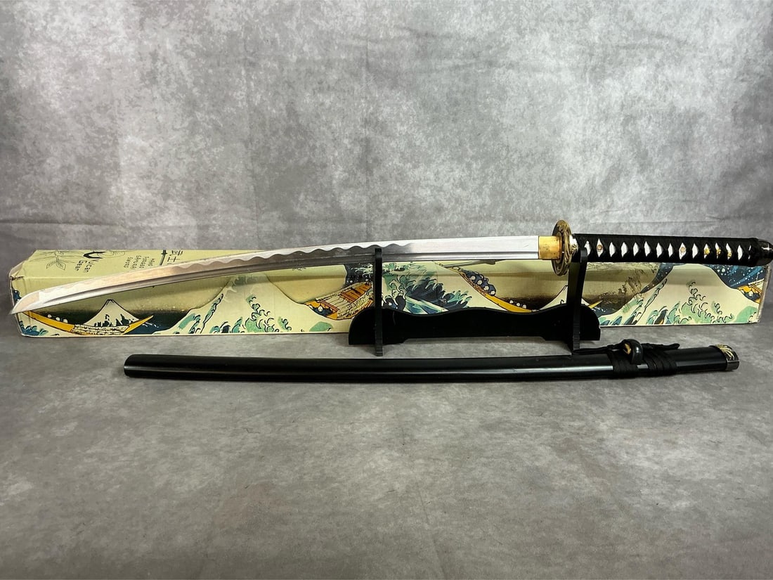 Vulcan Gear Samurai Sword Replica: Late 1900's hand forged Samurai sword. Replica sword with stand and black plastic scabbard by Vulcan Gear from China. In original box. Slight wear on blade, otherwise in good condition. Measures 1.5