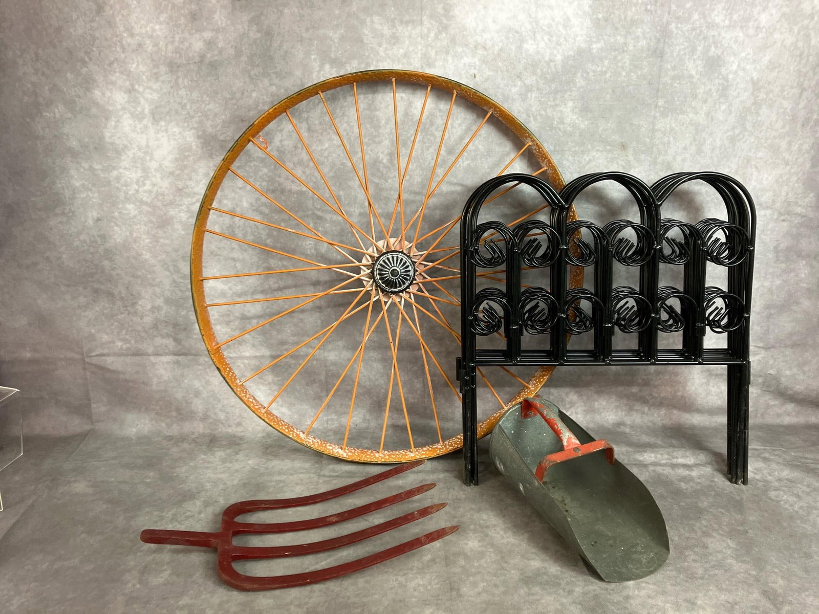 Wheel, Fencing, Feed Scoop & Potato Fork: Four decorative items. Orange painted wheel, 8 pieces of metal interlocking fence, potato or hay fork, and galvanized metal feed scoop. Scoop has paint loss, items in good condition. Wheel measures