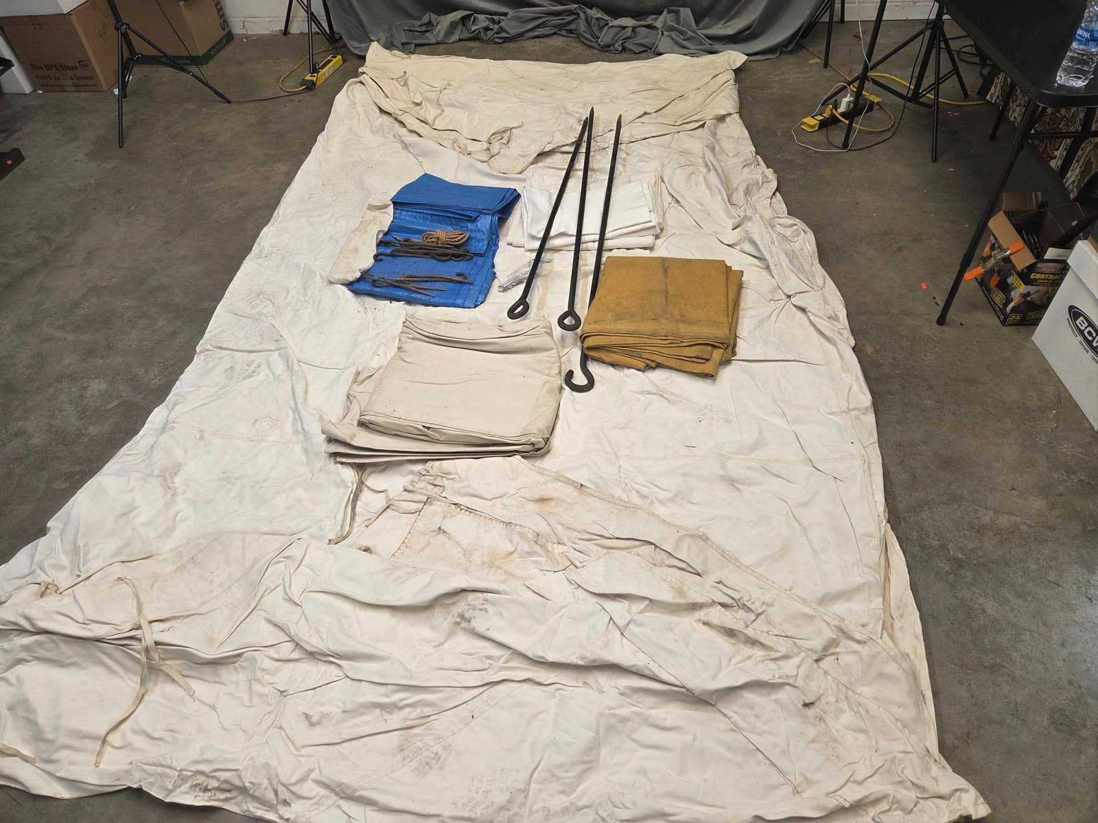 Colonial Reenactor's Tent: Late 20th century canvas colonial reenactor's tent with three ground cloths, one plastic tarp, twelve metal stakes, three large stakes, and two pine poles. Not set up and tested. Measures