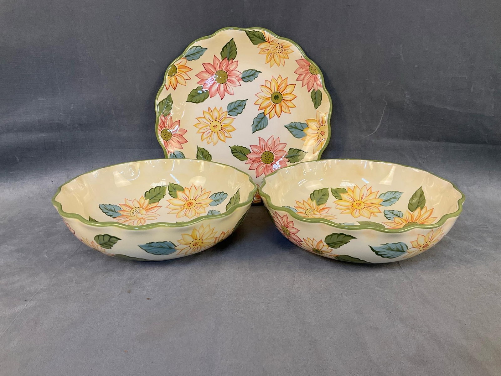 Longaberger Pottery: Lot of three late 20th century floral painted Longaberger dishes. Two large serving bowls and one circular serving platter. Good condition. Platter measures 14 inches in diameter x 1.5 inches tall.