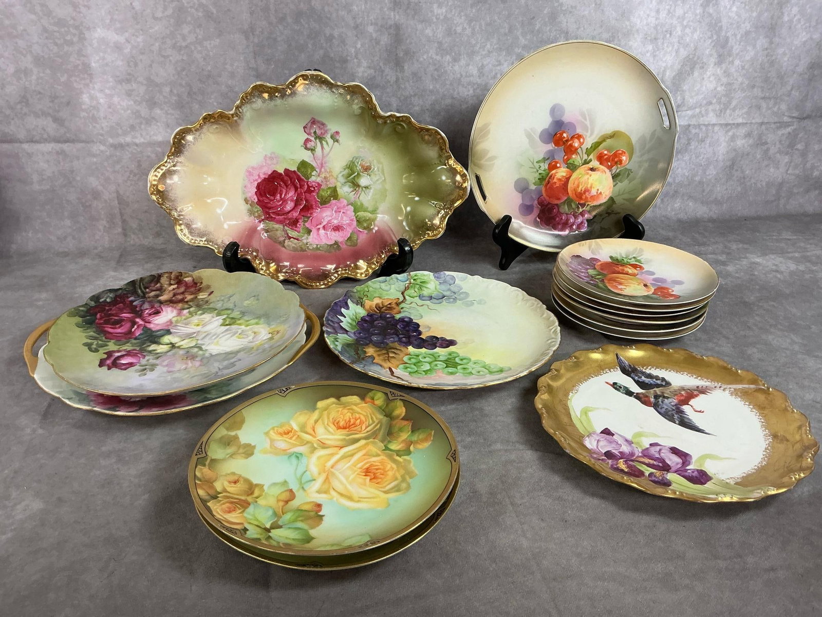 Vintage Porcelain Painted Plates: Fourteen early to mid 1900's hand painted plates. Altwassan German oblong tray, several French Limoges plates, and Bavarian made plates. Gold gilt edges are slightly worn, otherwise plates in good con