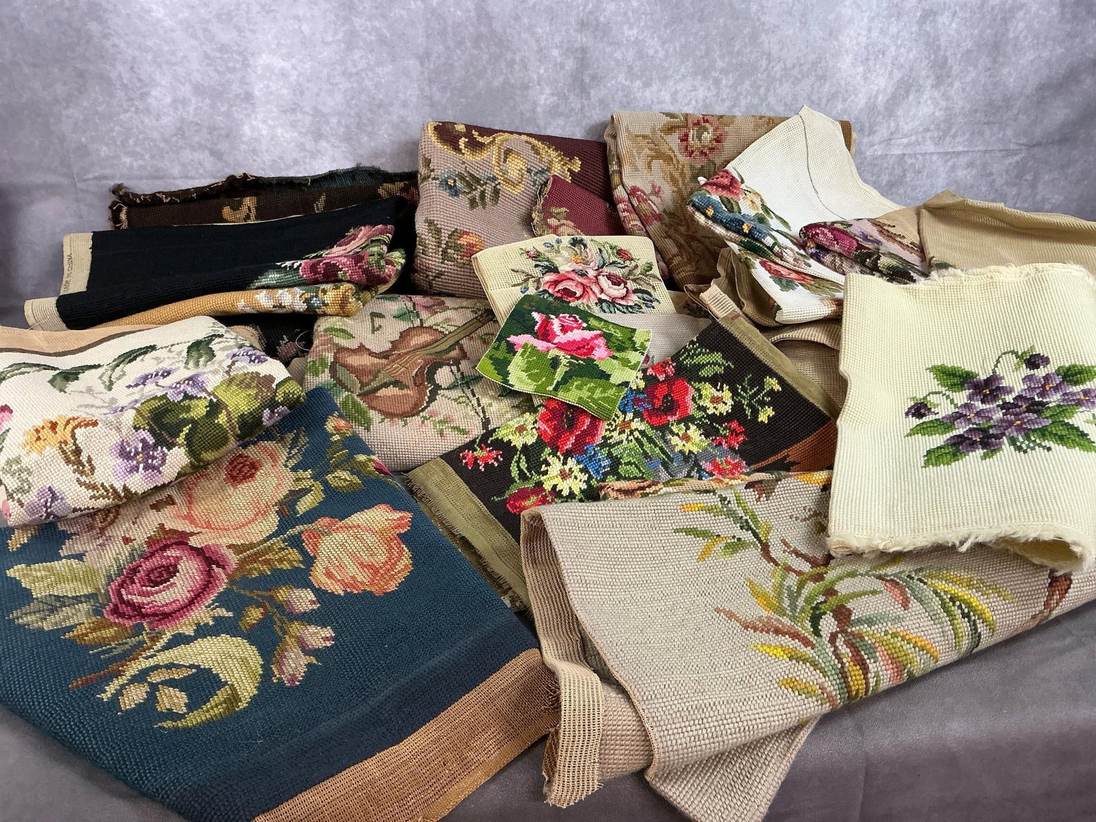 Vintage Needlework: Twenty-five or more needlepoint tapestry. Assorted colors, designs, and sizes, used for chair upholstery or art pieces. In good condition. Violin and music piece measures 21 inches wide x 43 inches