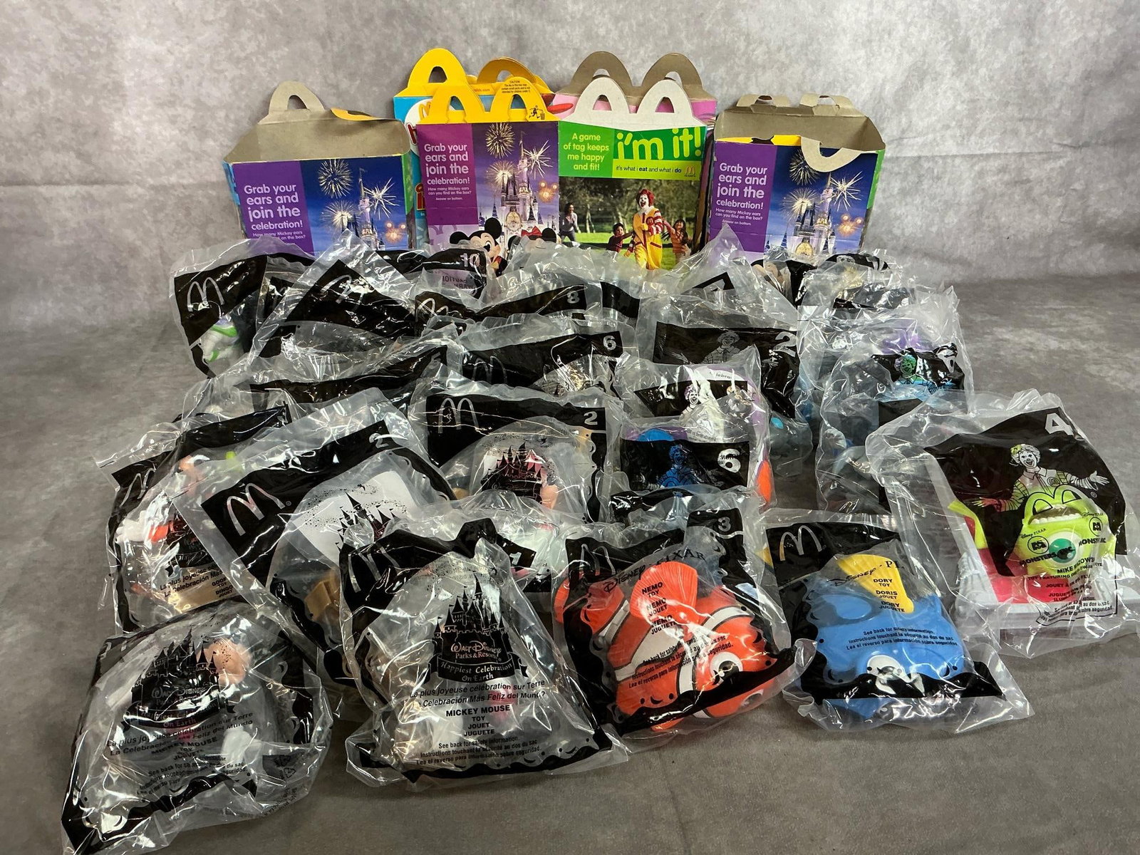 McDonald's Toys: Thirty-four 2001-2005 Happy Meal toys. Includes Disney Park Toys, Monsters Inc, Atlantis, Nemo and more. In original packaging. Average size is 4 inches wide x 5 inches tall.