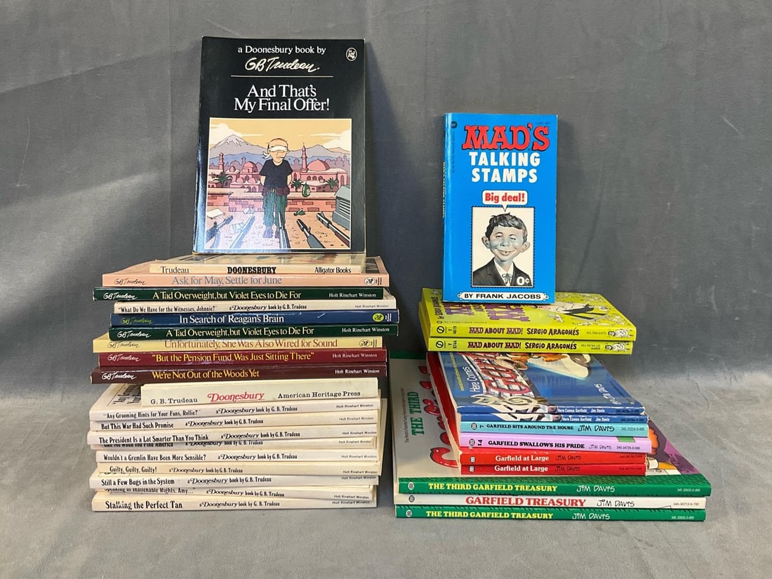 Comic Paperback Books: Approximately thirty two 1970's - 1980's vintage collectible Comic Book paperbacks. Featuring twenty Doonesbury Books by G.B. Trudeau. Three Mad Books, and nine Garfield Books by Jim Davis. Good